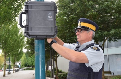 Officer installing the black cat device on a pole