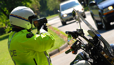RCMP traffic officer holding a radar gun against incoming traffic
