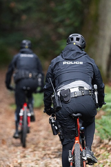 Two RCMP Bike Patrol Unit Officers riding down a bike path away from the camera