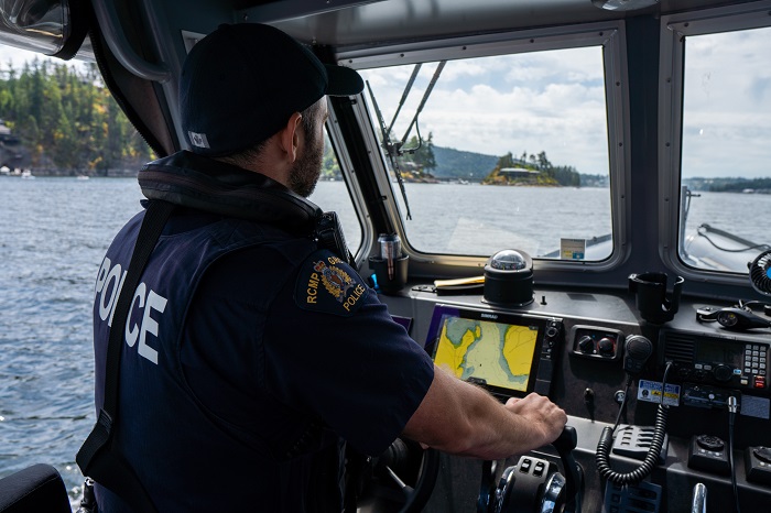 Un agent des services de police ruraux patrouille à bord d’un bateau de police.