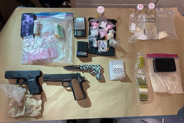 Display of weapons, drugs and drug paraphernelia layed out on table