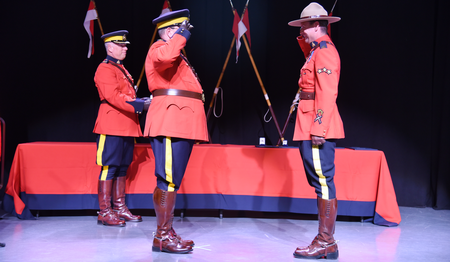 Photo of Sergeant Kyle Ushock saluting Chief Superintendent Brian Edmonds.