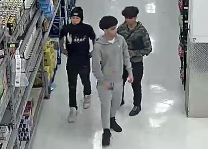 Vue de face des trois suspects qui se déplacent en groupe dans une allée du commerce