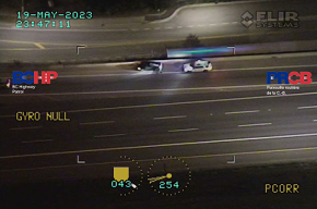 Vue aérienne prise de l’hélicoptère et montrant un véhicule de police derrière une voiture noire sur l’accotement