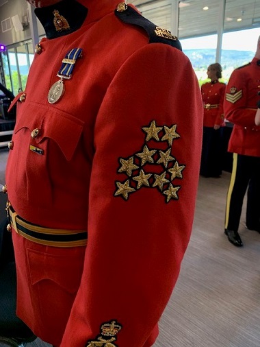 An RCMP red tunic depicting ten stars indicating fifty years of service.