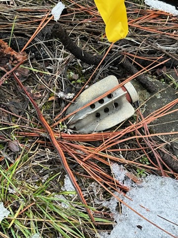 photo of tailfin of mortar round in ground