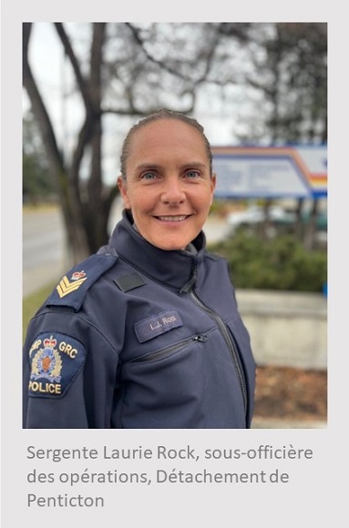 Femme blanche debout près d’une enseigne de la GRC et regardant par-dessus son épaule droite. Elle porte un blouson bleu de la GRC. Sous la photo, on peut lire : Sergente Laurie Rock, sous-officière des opérations, Détachement de Penticton.